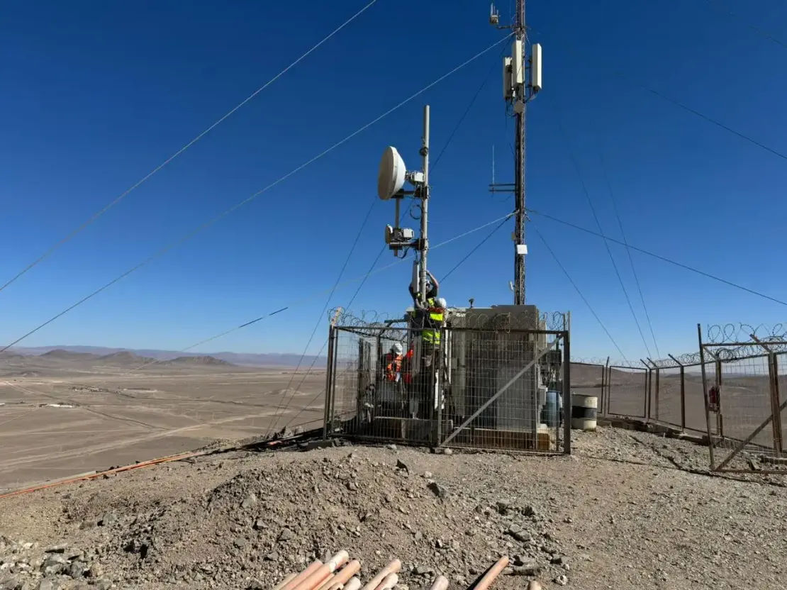 Tres trabajadores instalando una antena en el desierto